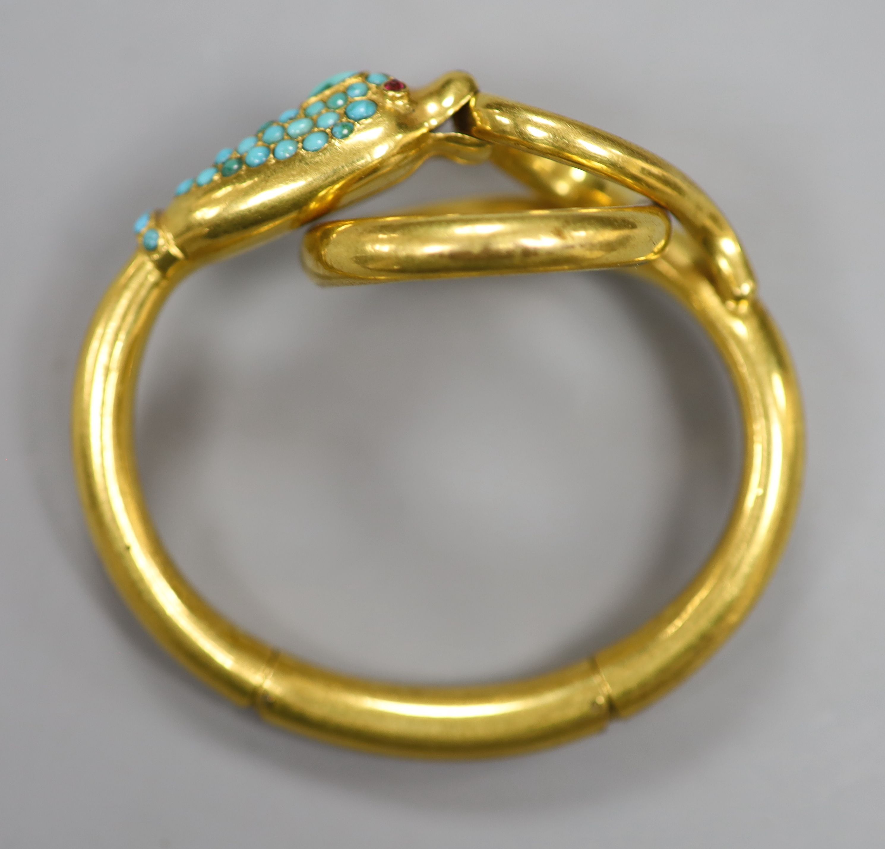 A Victorian pinchbeck and turquoise set hinged serpent bangle, with gem set eyes.